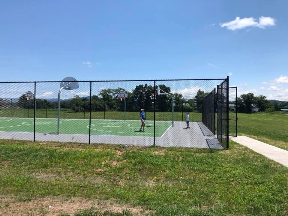 Tall black chain-link fence around a basketball court complex