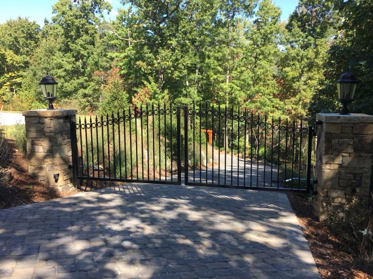 Iron double swing gate with stone pillars and lanterns