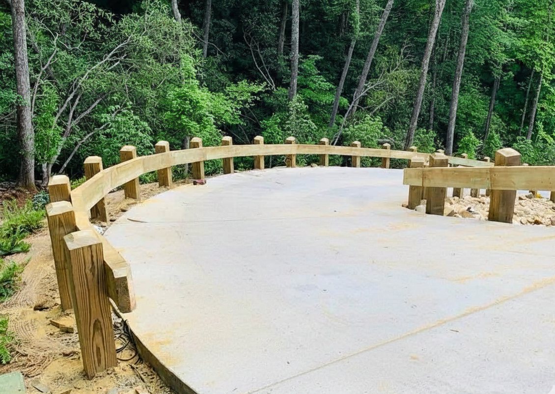 Timber post-and-rail guardrail around a new concrete pad