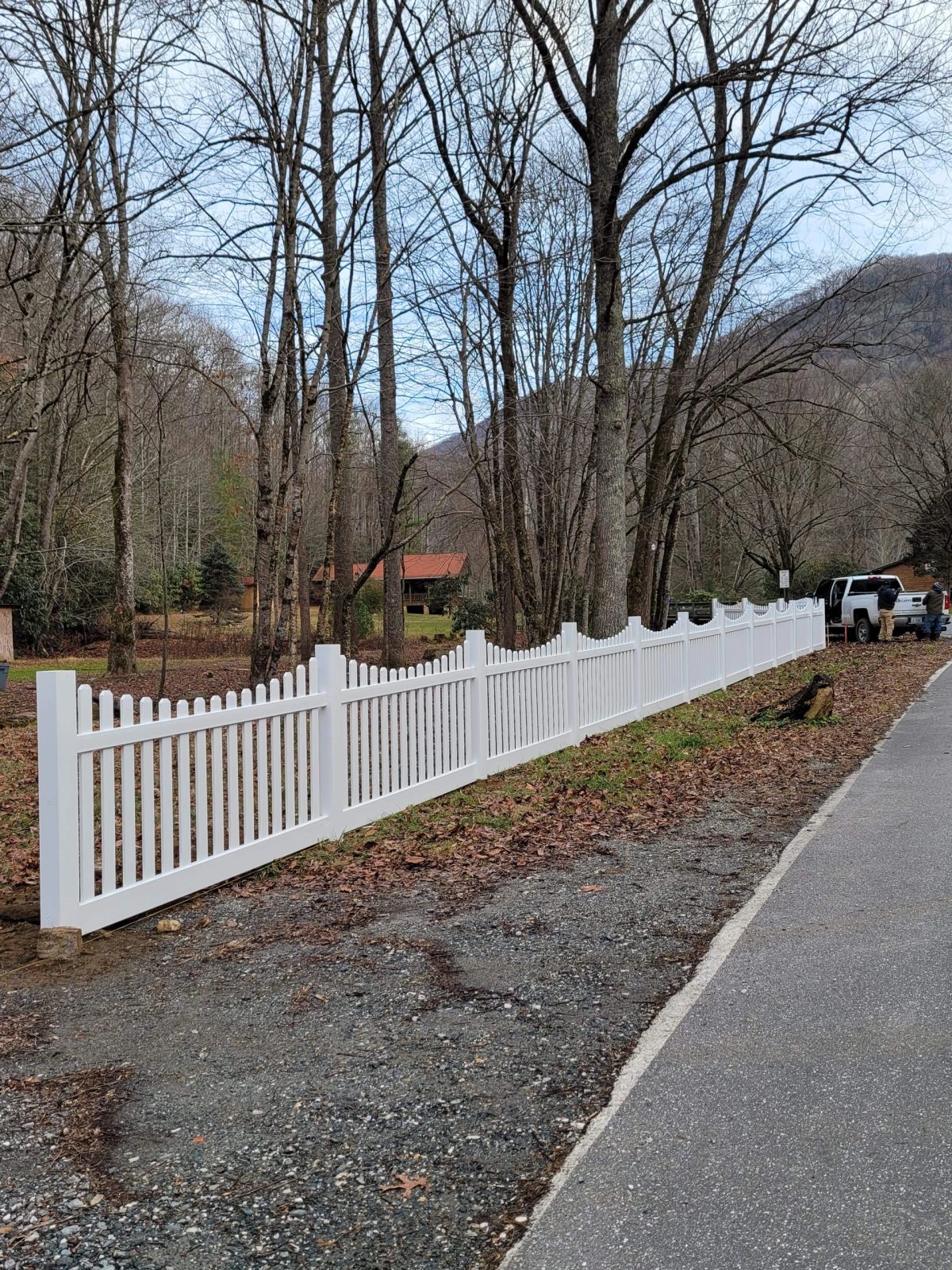 White vinyl scalloped picket fence with mountain backdrop
