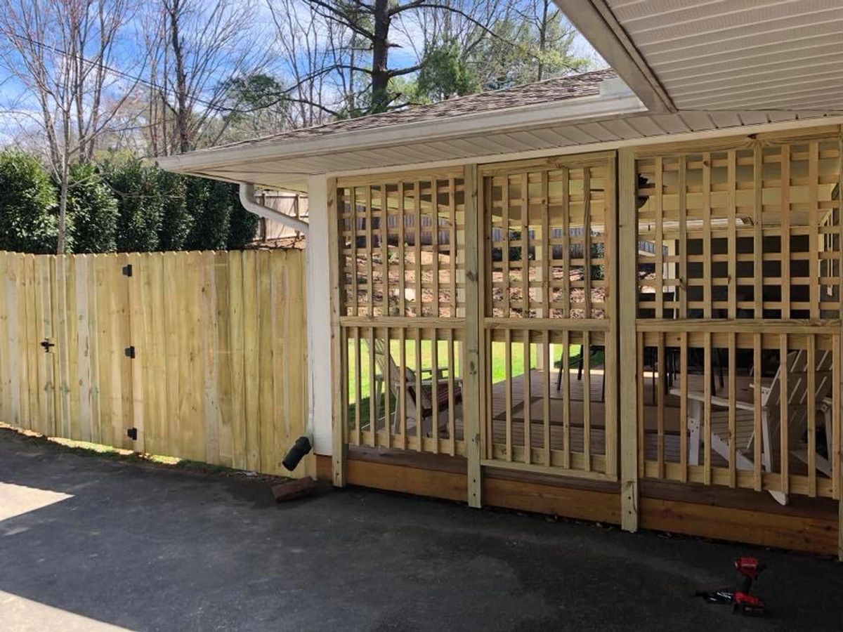 Dog-eared wood privacy fence with lattice porch enclosure